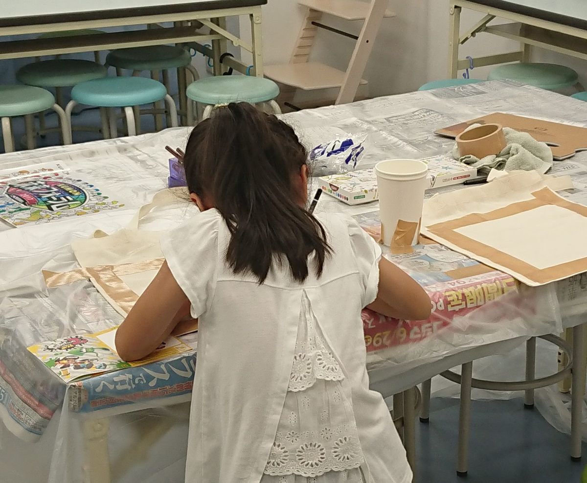 机に向かって制作する子供の後ろ姿
