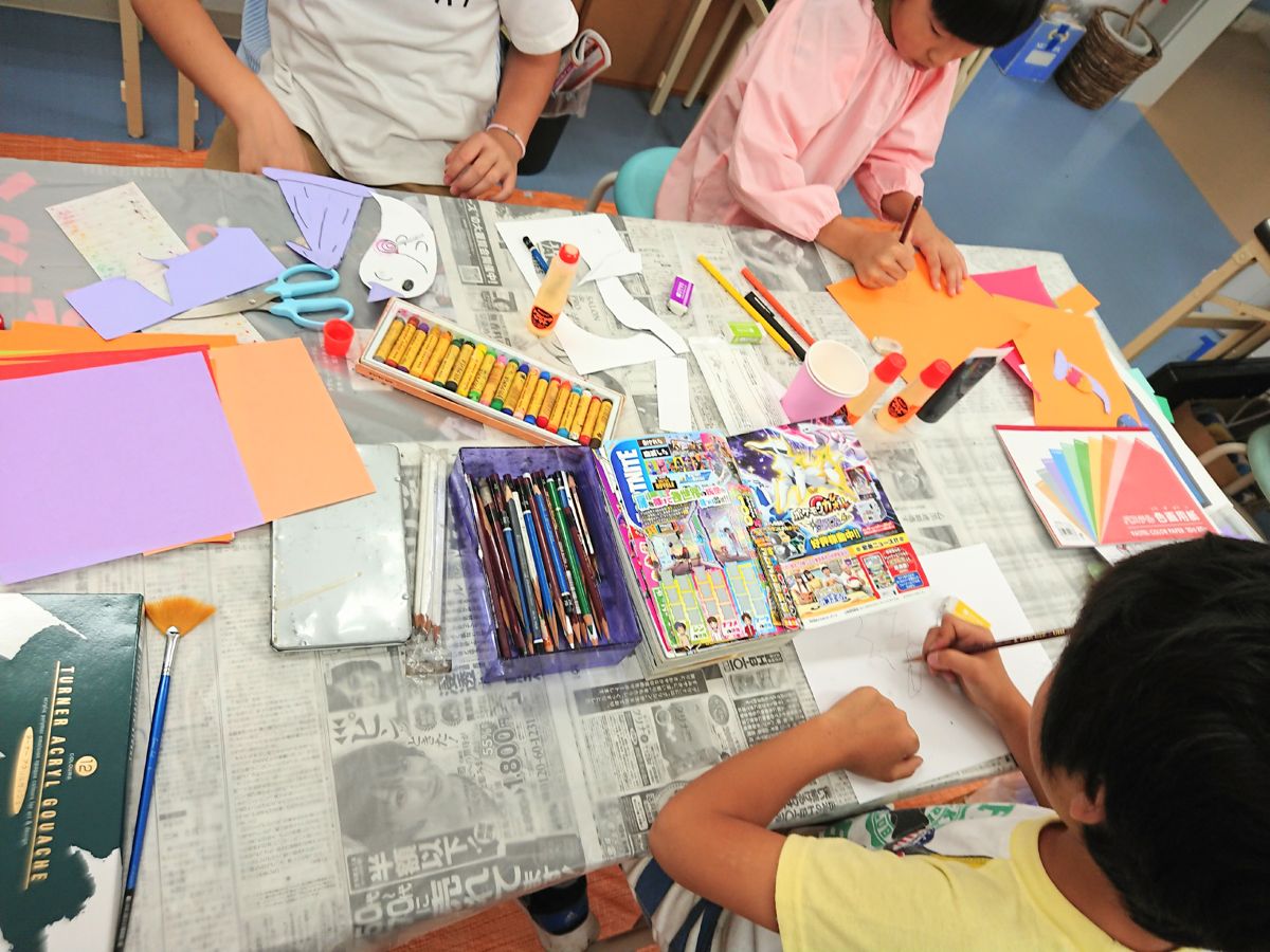 色紙で制作する子供たちの手元